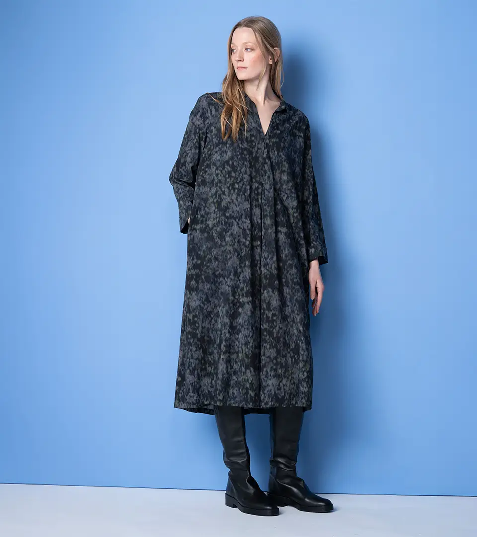 Woman in dark patterned midi dress and boots