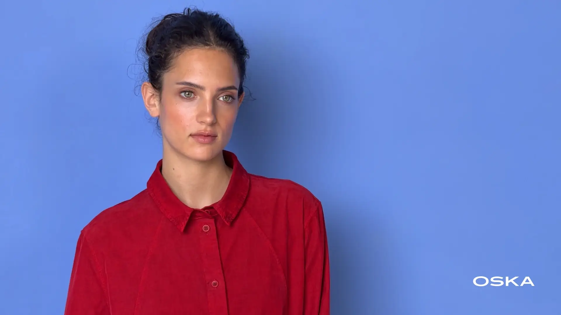 Woman in red shirt against blue background