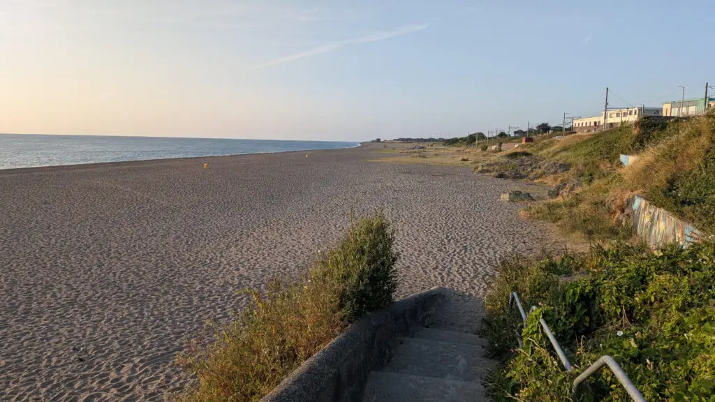 Empty sandy beach at sunset with seaside stairs