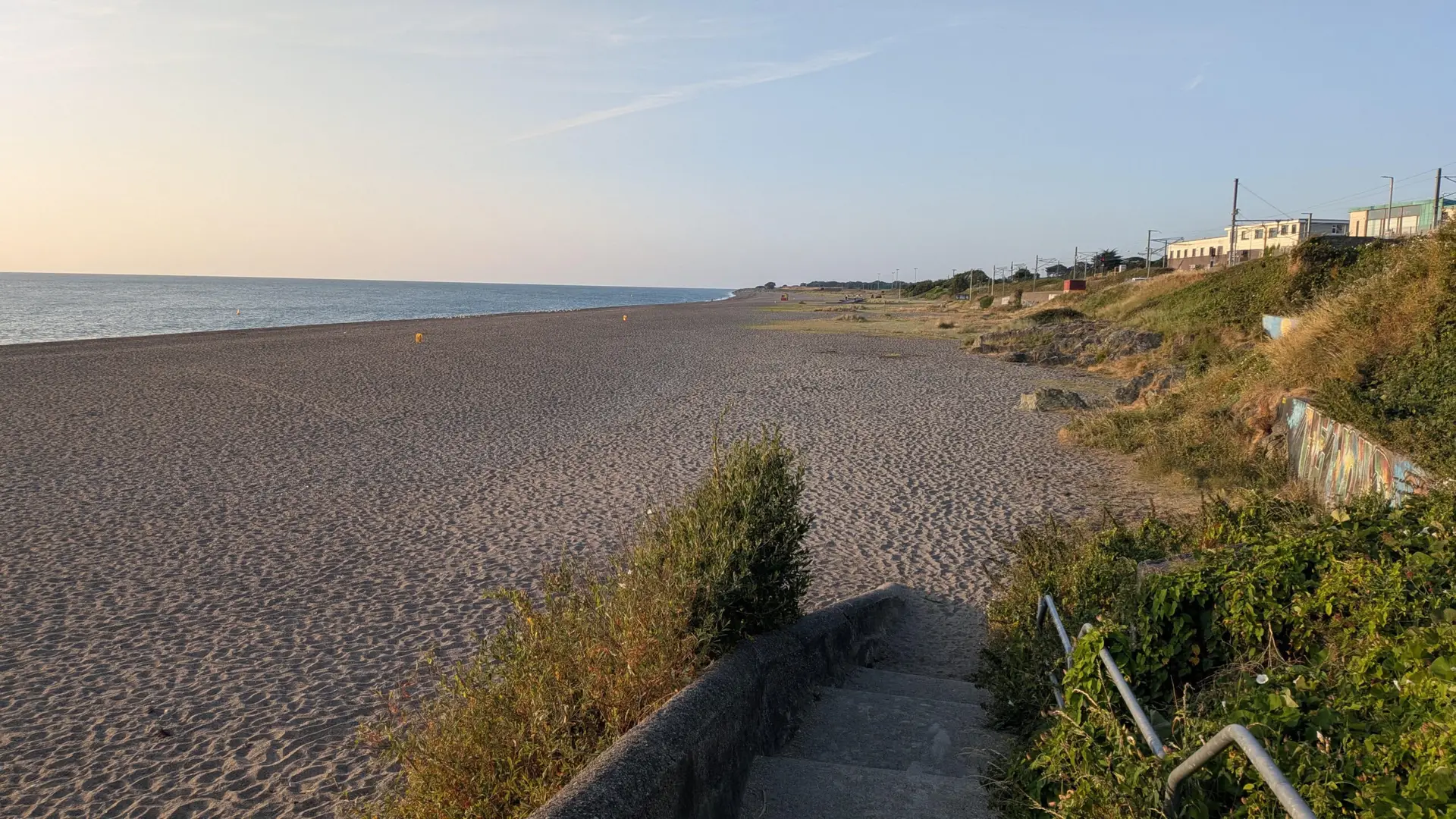 Empty sandy beach at sunset with seaside stairs