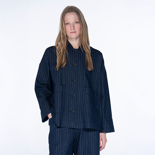 Woman in navy pinstripe oversized jacket and matching trousers.