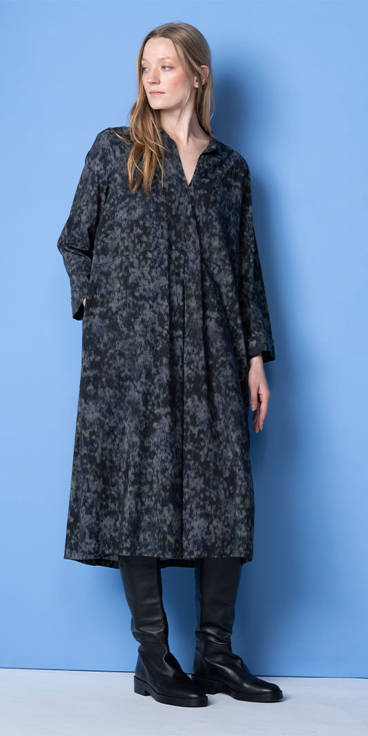 Woman in patterned midi dress and black knee-high boots.