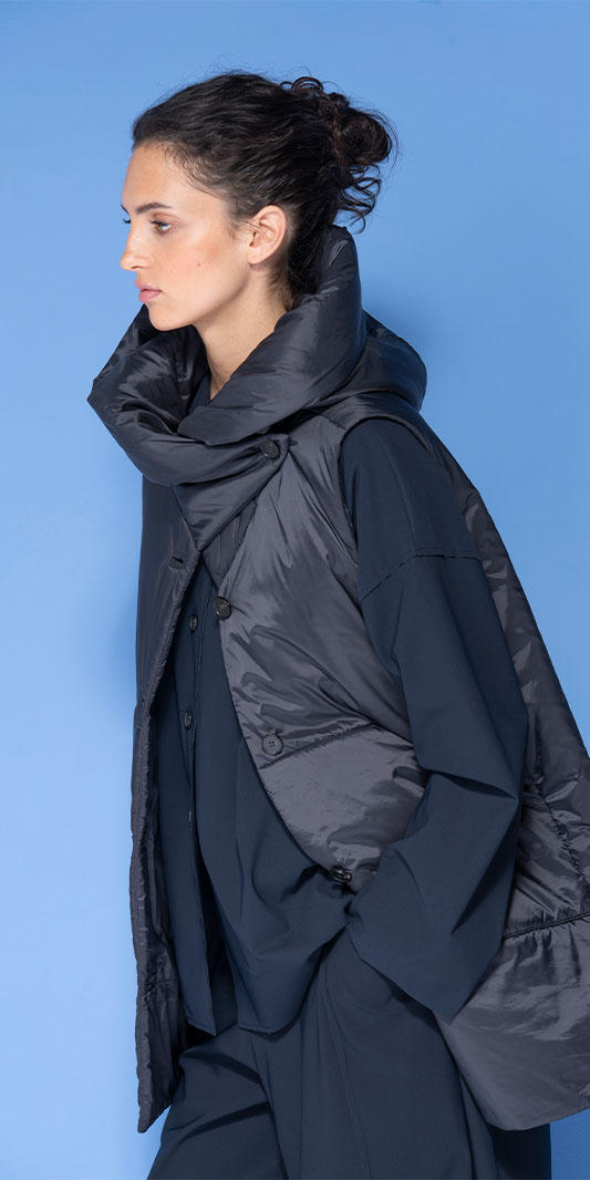 Woman wearing an oversized navy quilted puffer vest.