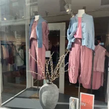Display of fashionable clothing in a store window.