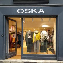 Clothing store display with stylish apparel.